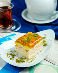 cake piece with cream topped with caramel syrup and pistachio