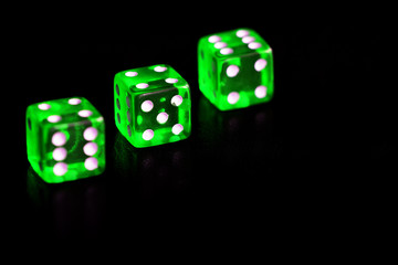 Green transparent dice on black background close-up. Gambling сoncept