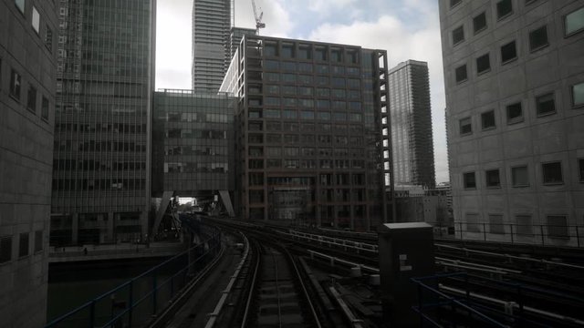 Skytrain tracks in business district of metropolis. Action. Skytrain in big city with skyscrapers in cloudy weather. Skytrain passes by skyscrapers with gloomy atmosphere. Gotham city