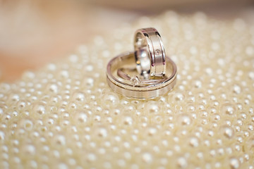 Obraz na płótnie Canvas wedding rings on white pearl background