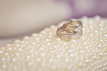 Obraz na płótnie Canvas wedding rings on white pearl background