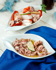 platter of squids garnished with lemon served on white table