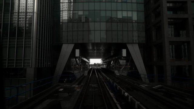 Skytrain tracks in business district of metropolis. Action. Skytrain in big city with skyscrapers in cloudy weather. Skytrain passes by skyscrapers with gloomy atmosphere. Gotham city