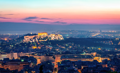 Night view of the Athens skyline, in Greece, with the Acropolis dominating the picture. Filopappos Hill and the city of Piraeus are the background.