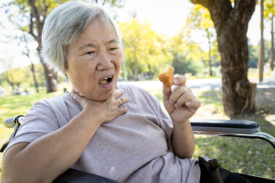 Asian senior woman suffers from choke and cough,clogged up food,elderly people choking during feeding,food might stuck in the throat and suffocate with sever pain injury, asphyxia,suffocation concept
