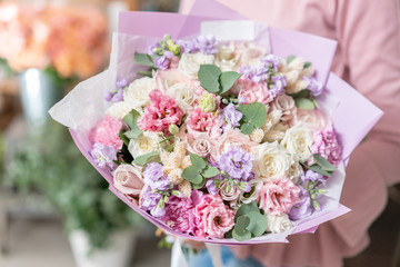 European floral shop. Beautiful bouquet of mixed flowers in womans hands. the work of the florist at a flower shop. Delivery fresh cut flower.