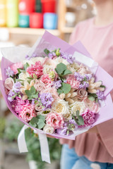 European floral shop. Beautiful bouquet of mixed flowers in womans hands. the work of the florist at a flower shop. Delivery fresh cut flower.