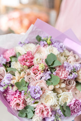 European floral shop. Beautiful bouquet of mixed flowers in womans hands. the work of the florist at a flower shop. Delivery fresh cut flower.