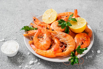 Steamed shrimps with lemon and herbs. Seafood, shellfish. Shrimps prawns on plate.