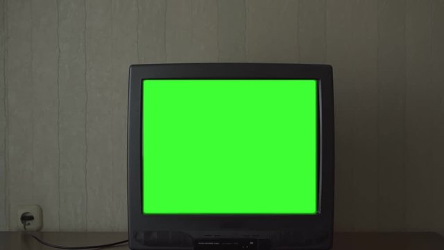 unplugged from digital television TV-set with chromakey screen stands on drawer unit extreme close view