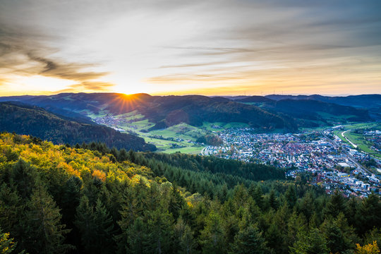 Germany, Wide panorama view over black forest village haslach im kinzigtal above green tree tops at sunset, a hiking paradise