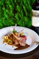 roasted lamb ribs served with potato and sauce
