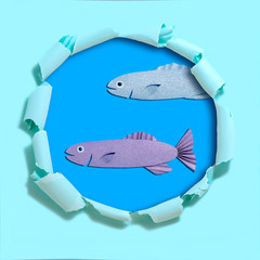 Handmade paper fish on torn paper with hole