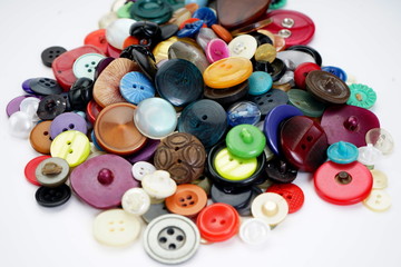 Many different buttons on a light background. Selective focus. Home needlework
