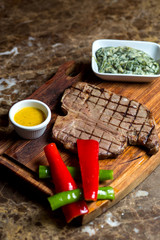 beef steak served with yogurt and herbs mixture, red and green peppers