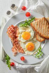 Homemade breakfast with eggs, bacon and tomatoes