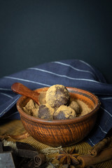 Craft chocolate truffles with spices in a clay Cup on a black background