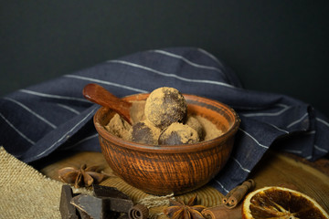 Craft chocolate truffles with spices in a clay Cup on a black background