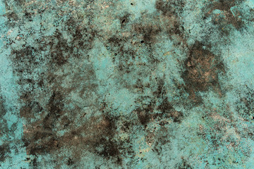 Texture of concrete wall or Cement floor background with a worn green paint, damaged paint with some holes and cracks with dirty black mold, fungus. Close up moss and lichen on the damp green wall.