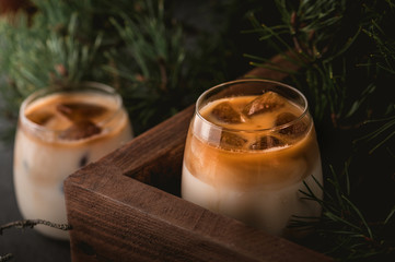 Iced coffee cocktail with milk on dark background