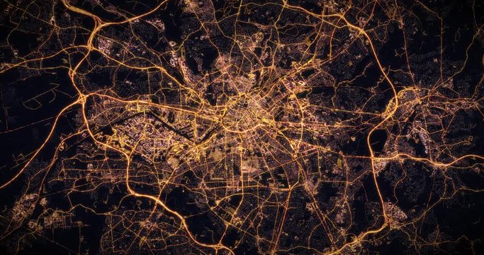 Aerial night view of city of Manchester, UK. Traffic and street light glowing. Camera flying high above, moving closer and rotating from space filming cinematic straight down. 3d animation rendering.
