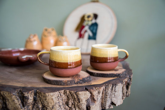 Two handmade ceramic coffee cups on a wooden table