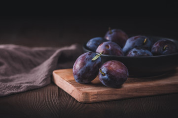 Fresh organic plums on dark background