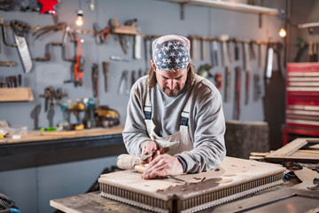 Carpenter working on a old wood in a retro vintage workshop.