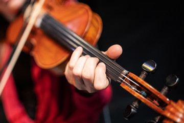 Female violin player. Unrecognizable person, focus on the fingers. Live classical / traditional music concept., fe