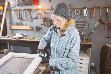 Carpenter working on the old wood in a retro vintage workshop.