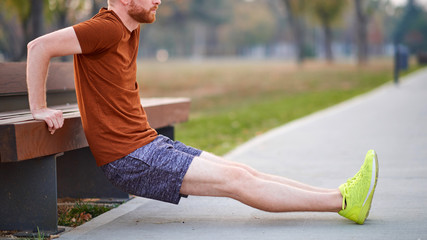 Young man exercising / stretching in urban park.
