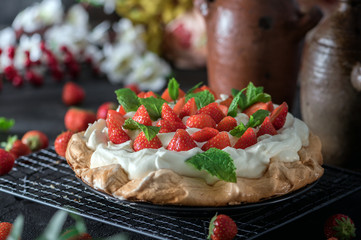 Chocolate Cake "Pavlova" with fresh strawberry and mint on dark background