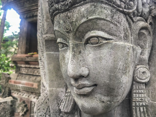 Fototapeta na wymiar Beautiful face of a stone statue in front of a sacred temple in Indonesia, Bali