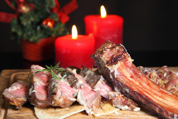 Rib eye steak on the New Year's table. Steak rib eye roast on a wooden board with sauce and salt....