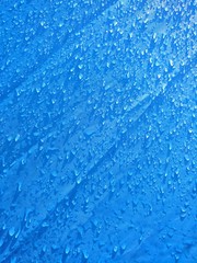 Obraz premium background of small water drops on blue synthetic material