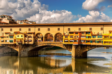 Obraz premium Ponte Vecchio Florence, Tuscany, Italy, Old Bridge, medieval stone arch bridge over the Arno River and with many small shops along it, Europe. UNESCO World Heritage Site