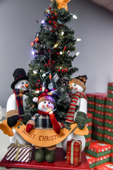 Decorated christmas tree with artificial snowmen with multi-color lights with a holly merry glow decor ideas for winter holidays Christmas and new year