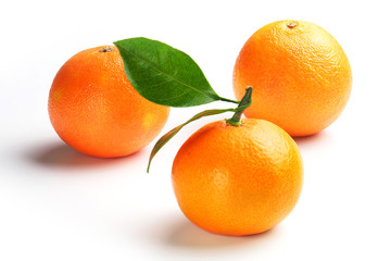 Yellow ripe tangerines with green leaves on a white background