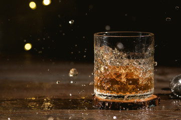 Glass of scotch whiskey on dark background