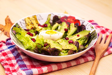bowl with avocado lettuce and pomegranate