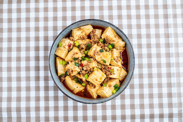 A bowl of Chinese national dish spicy spicy mapo tofu on the table