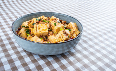 A bowl of Chinese national dish spicy spicy mapo tofu on the table