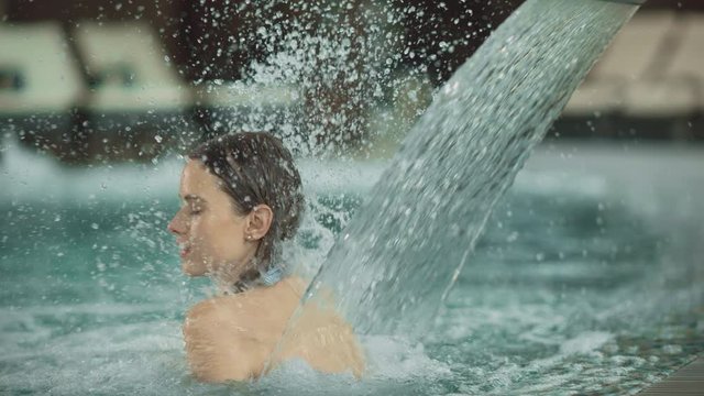 Closeup woman getting hydrotherapy at pool. Girl having spa treatment at pool