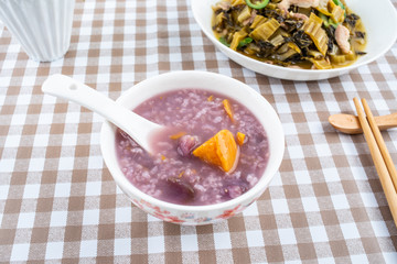A plate of sauerkraut fried lean meat and a bowl of sweet potato porridge on the table
