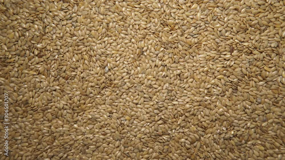 Wall mural Golden raw flax seeds linseed as natural food background or grain texture. Flaxseeds full of omega 3 fatty acids. Top down view. Healthy diet organic nutrition