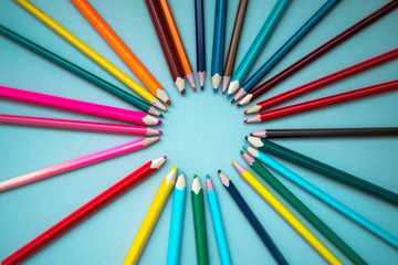many multi-colored pencils on isolated on a blue background