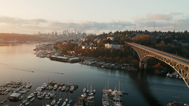 Drone Aerial Push past Aurora Bridge on Lake Union with Seattle Skyline in background and lake rowers. During sunrise. Fremont, Seattle, WS