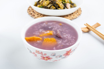 Purple sweet potato porridge in a bowl on white background