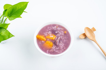 Purple sweet potato porridge in a bowl on white background