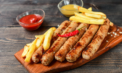 Grilled lunch hot sausages with French fries, ketchup and mustard ,  sausages pork beef